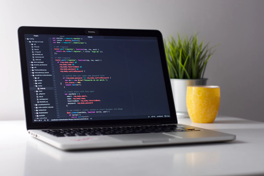 Estação de trabalho com notebook exibindo linhas de programação